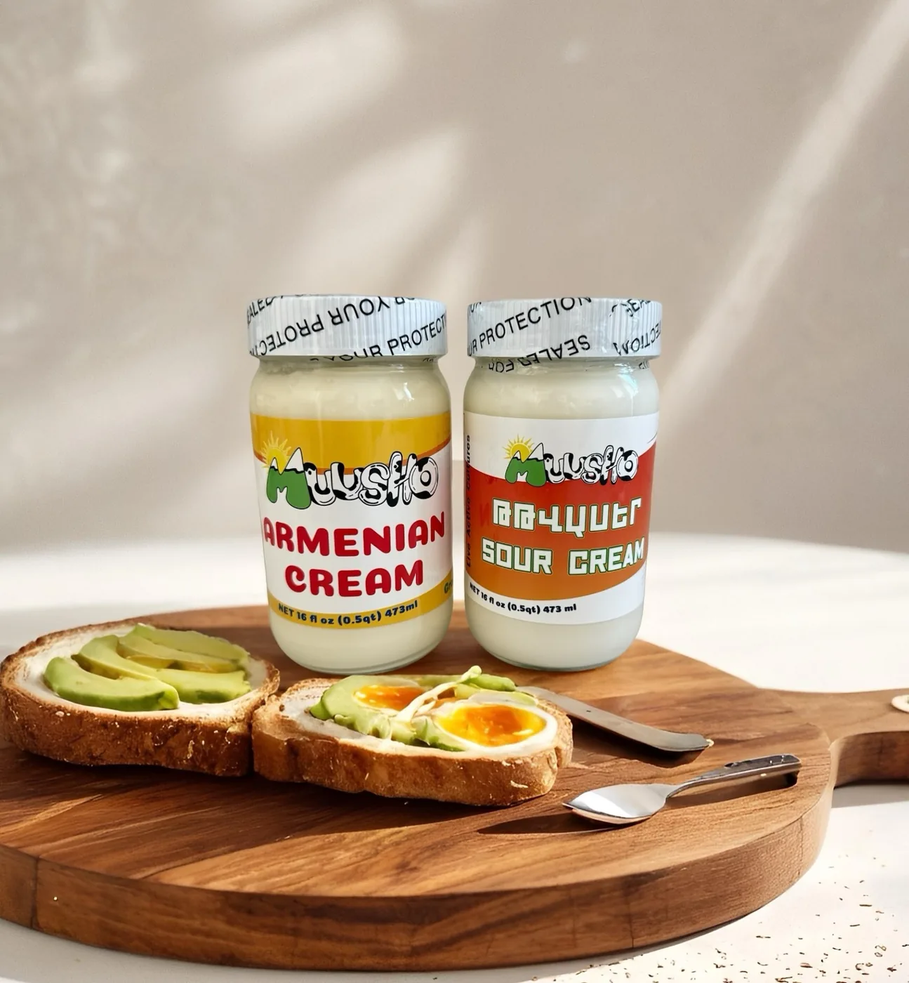 Muusho Armenian cream and sour cream jars with avocado toast on a cutting board