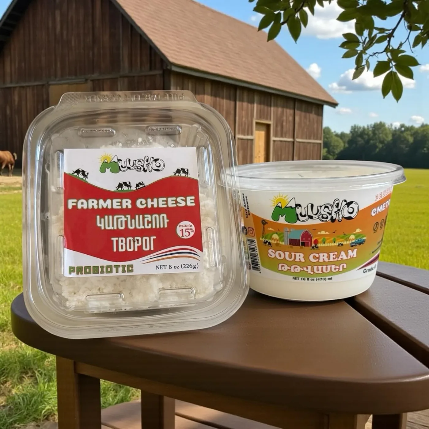 Muusho farmer cheese and sour cream on a wooden table in front of a red barn