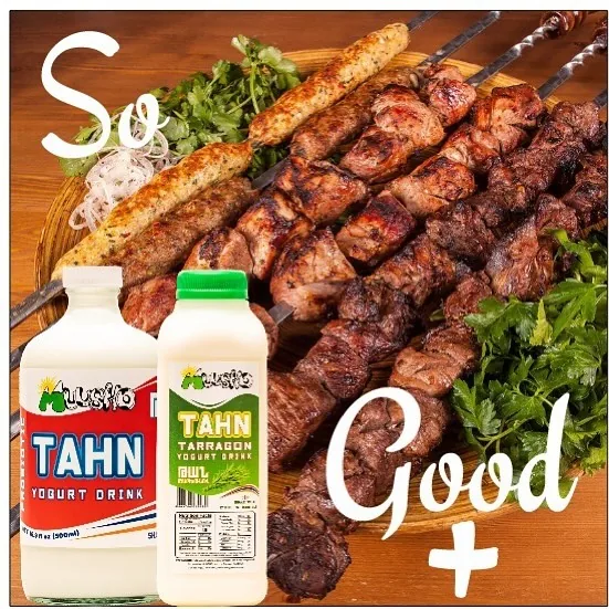 Muusho Tahn and Tarragon Tahn bottles beside a platter of khorovats skewers and fresh herbs